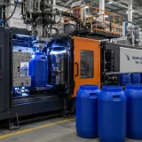 100 litre blow moulding machines in India operating in a modern industrial factory with automated production and blue plastic containers